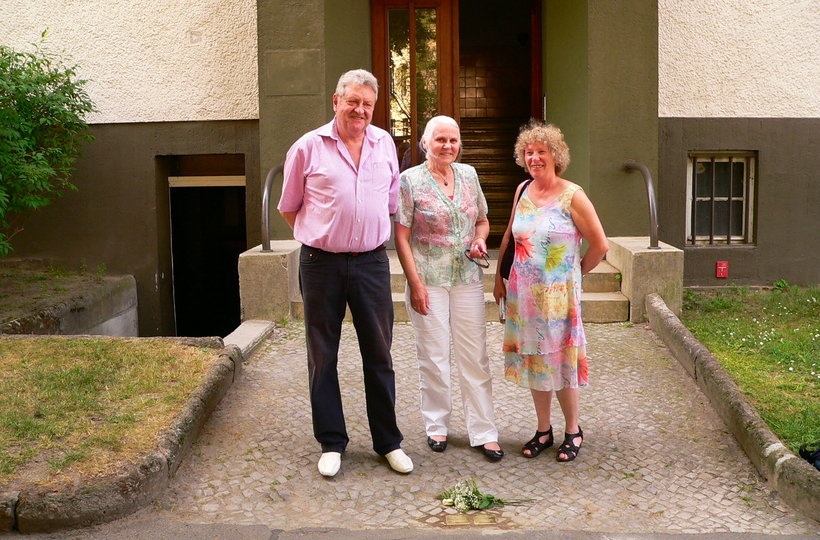 Drei Mitglieder der Arbeitsgruppe Stolpersteine stehen vor dem Hauseingang Albrechtstr. 59a, zu Füßen die beiden neuen Steine